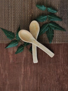 A wooden spoon and a wooden spoon with leaves on it