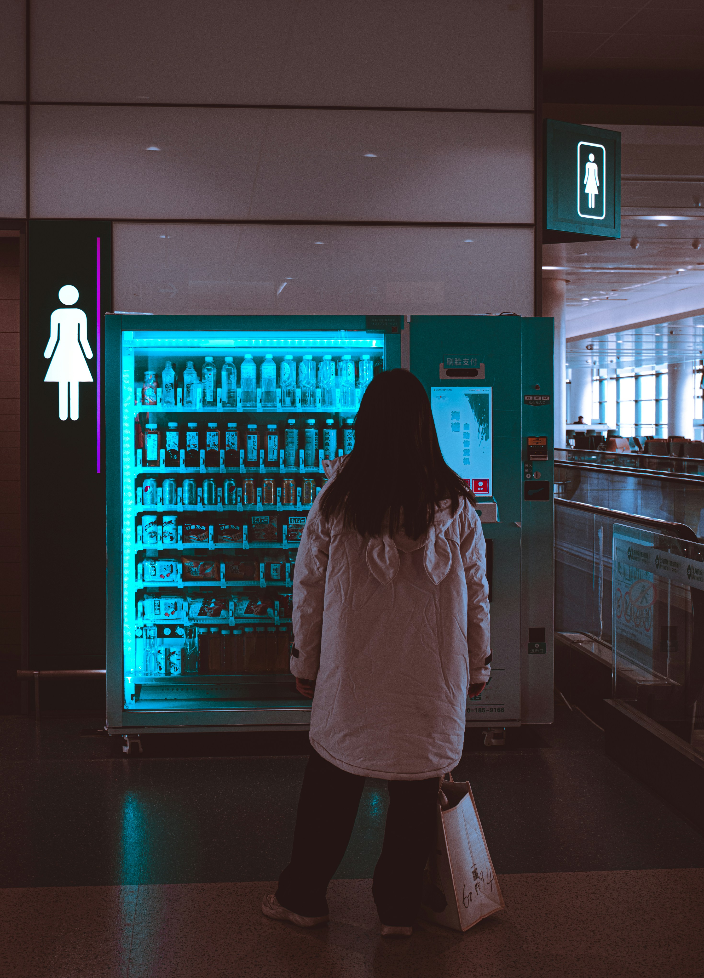 A woman standing in front of a vending machine