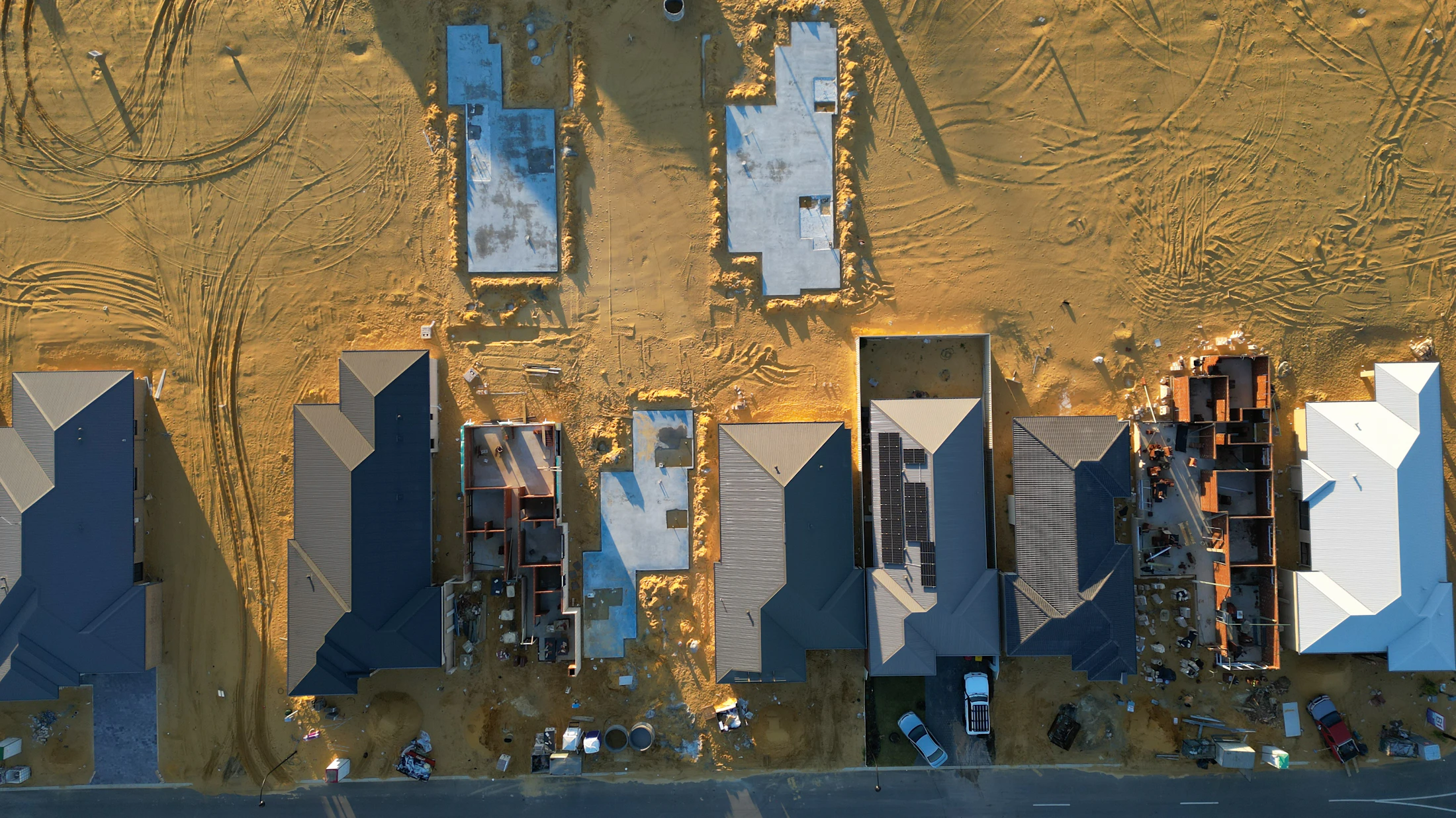 Pogled iz zraka na gradbišče z novimi temelji in objekti.