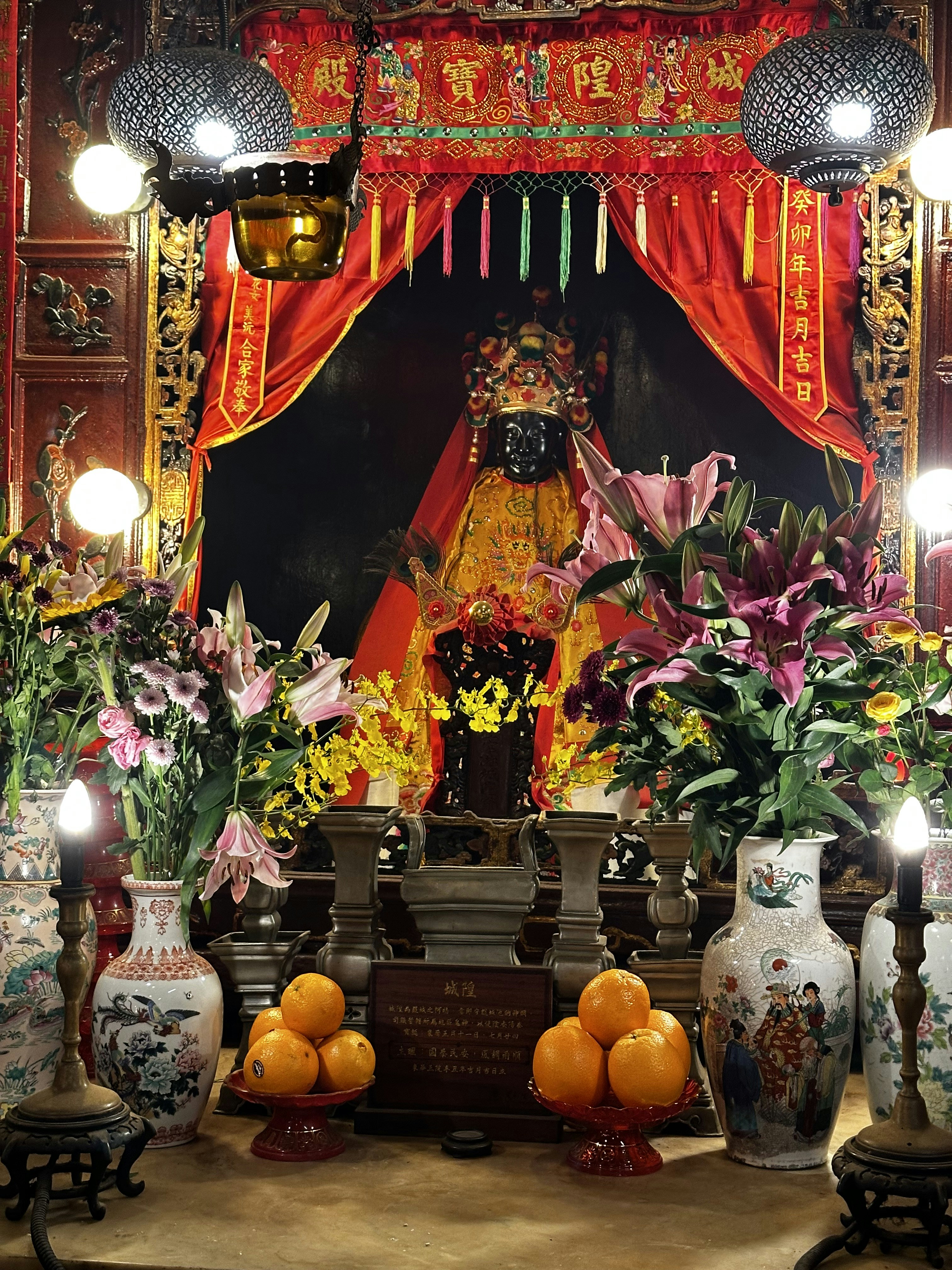 A shrine with flowers and vases in front of it