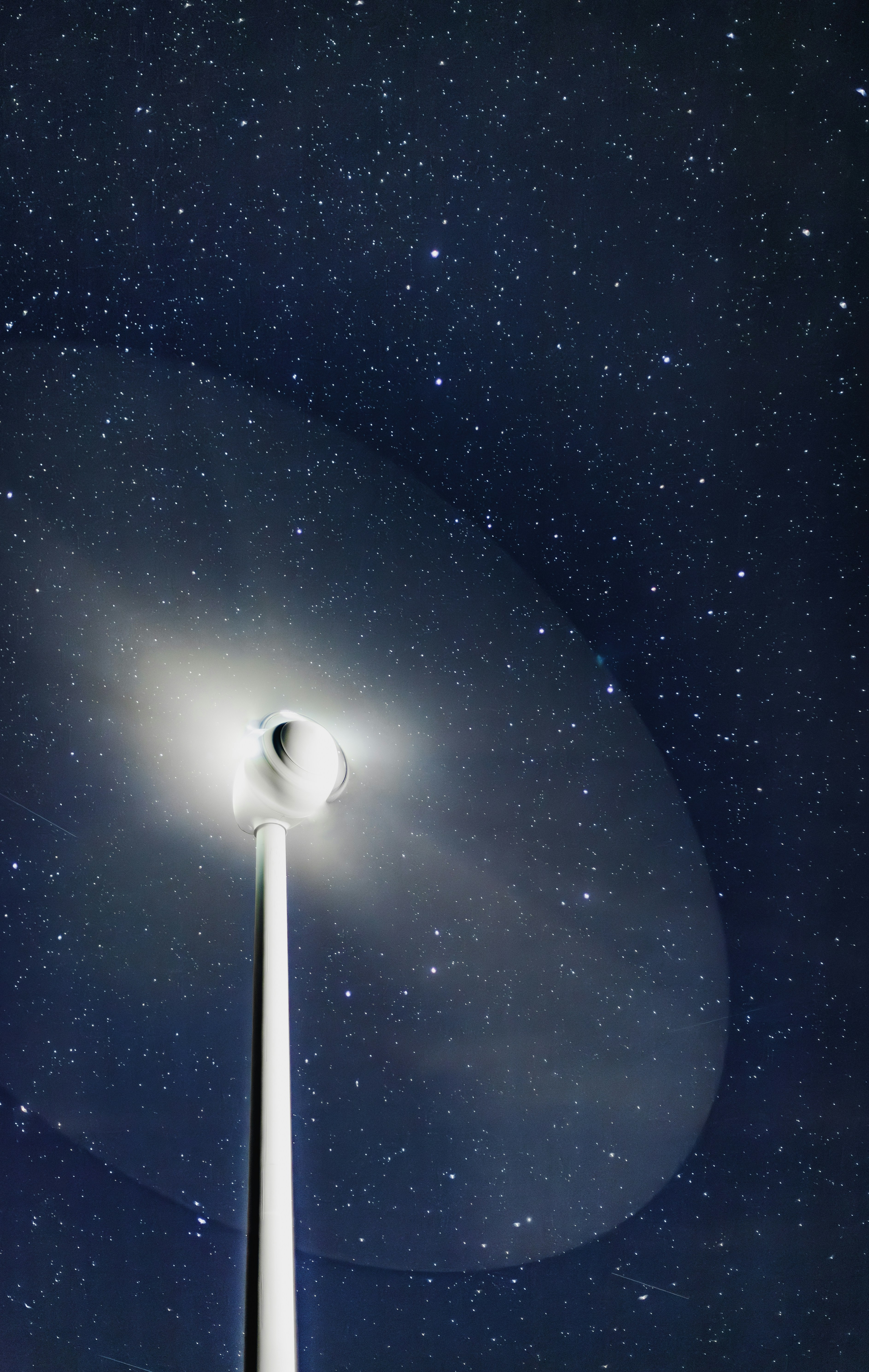 Un alto poste blanco bajo un cielo nocturno lleno de estrellas