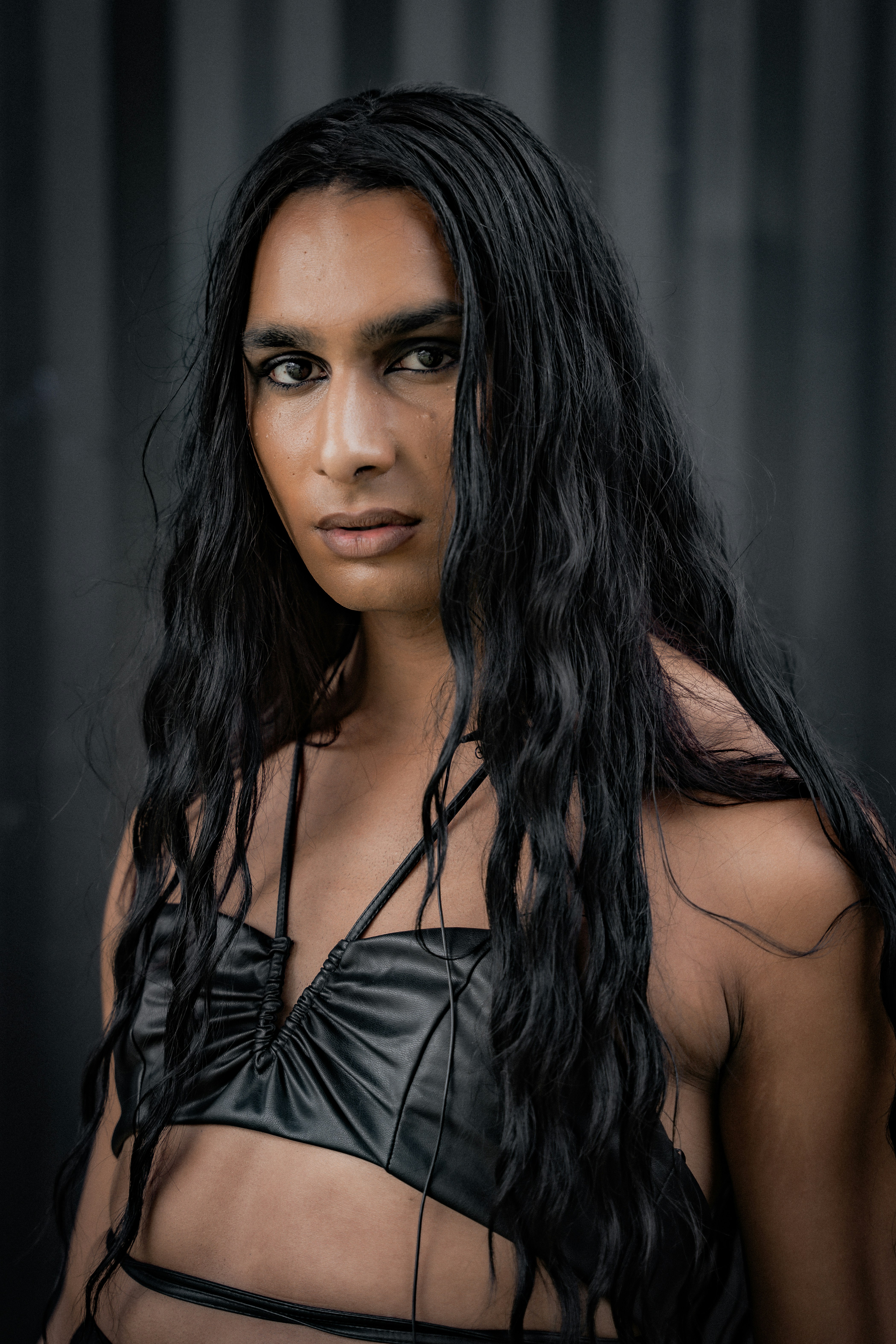 A woman with long black hair wearing a leather outfit