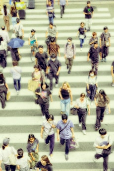 A crowd of people walking across a cross walk