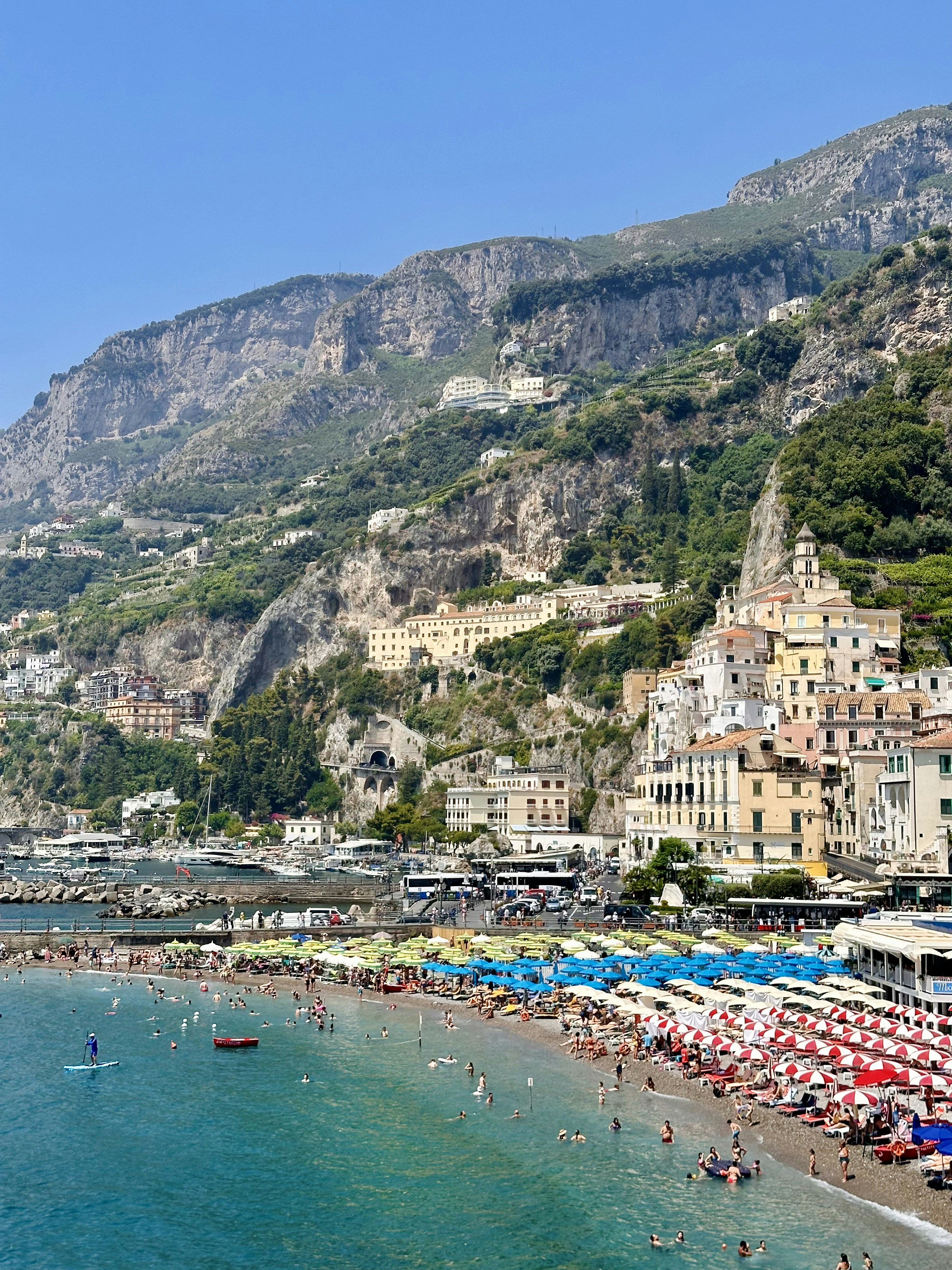 A beach with many umbrellas and people on it