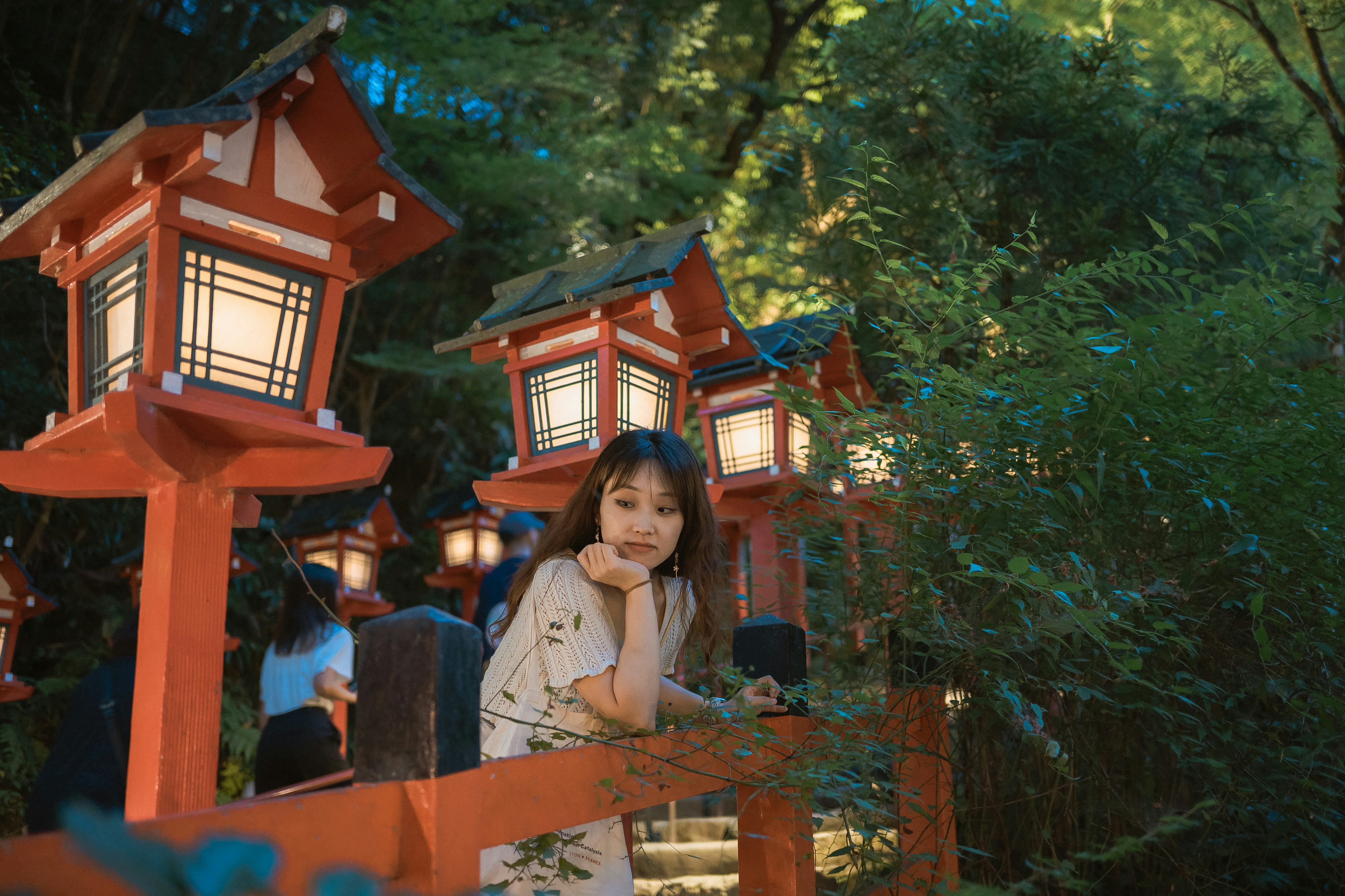 A little girl standing in front of some lanterns