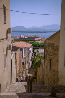 A narrow alley way with a view of a body of water