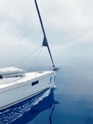 A white sailboat floating on top of a body of water