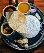 A plate of food with rice and sauces
