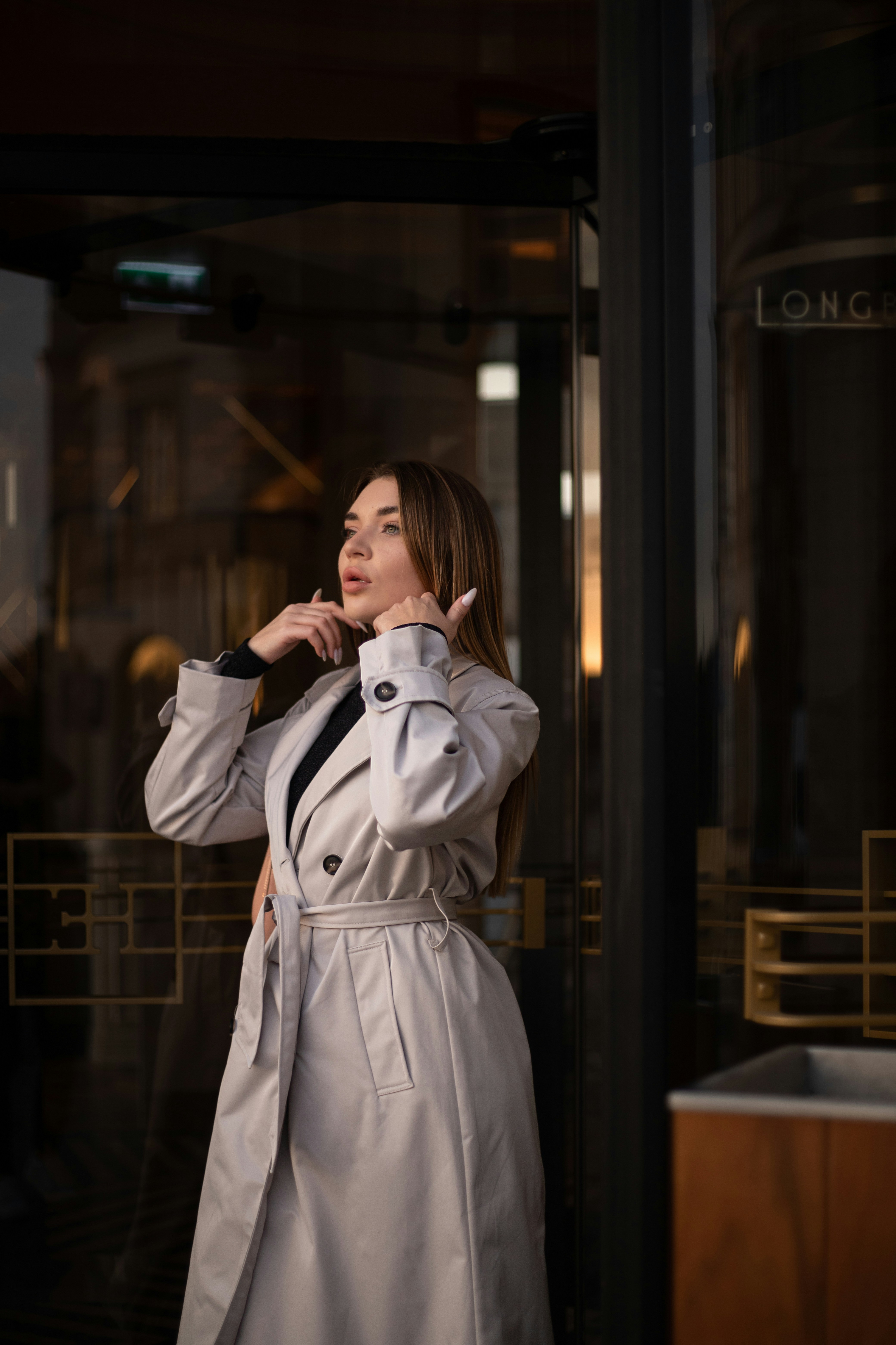 A woman in a trench coat talking on a cell phone