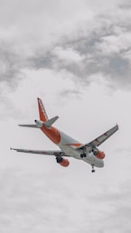 A large jetliner flying through a cloudy sky