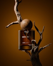 A bottle of tic skin oil sitting on top of a tree branch