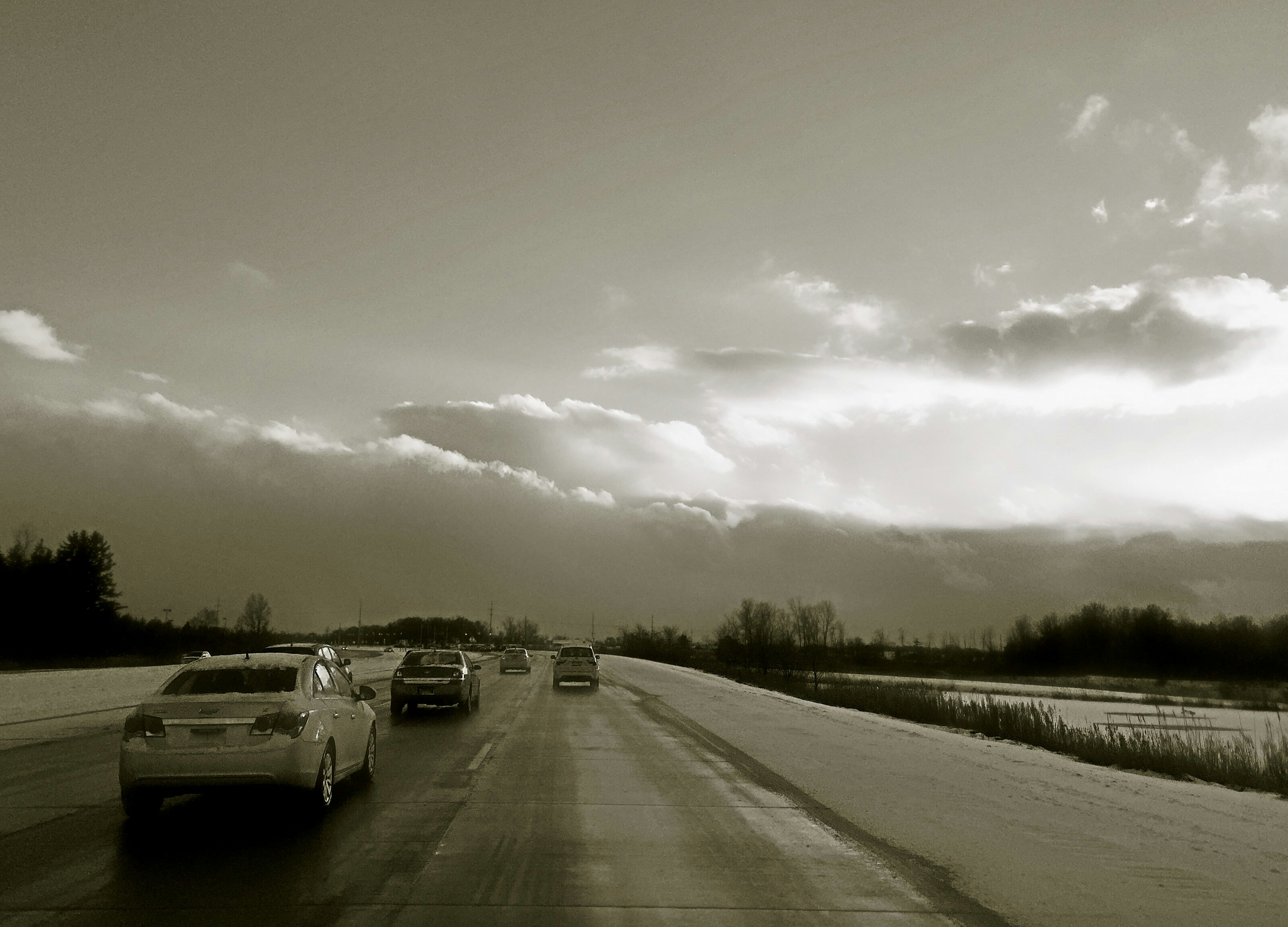 A black and white photo of cars on a highway