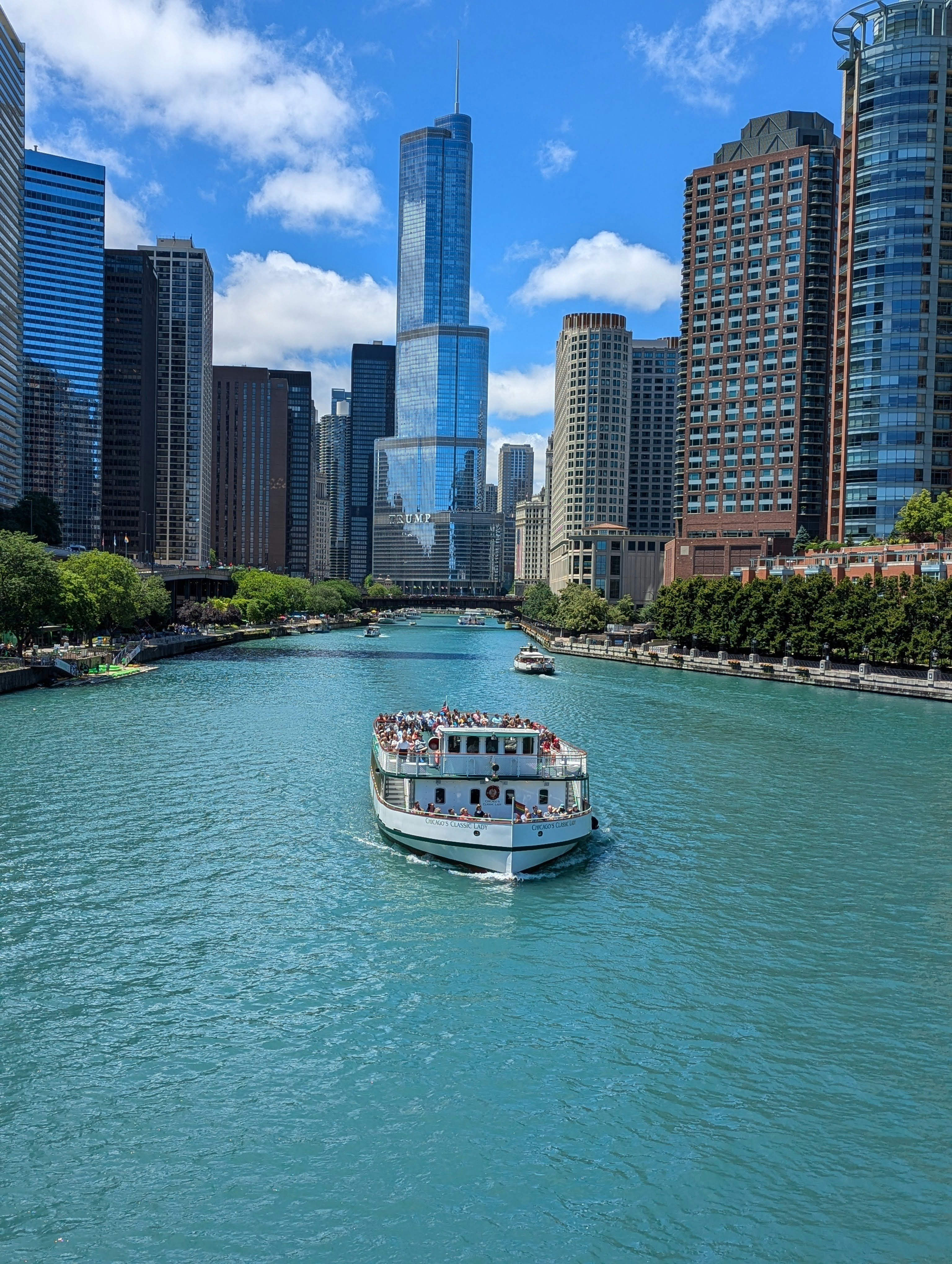 A boat traveling down a river next to tall buildings