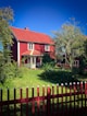 A red house with a red fence in front of it