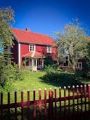 A red house with a red fence in front of it