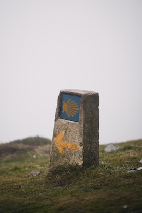 A stone marker with a blue and yellow arrow painted on it