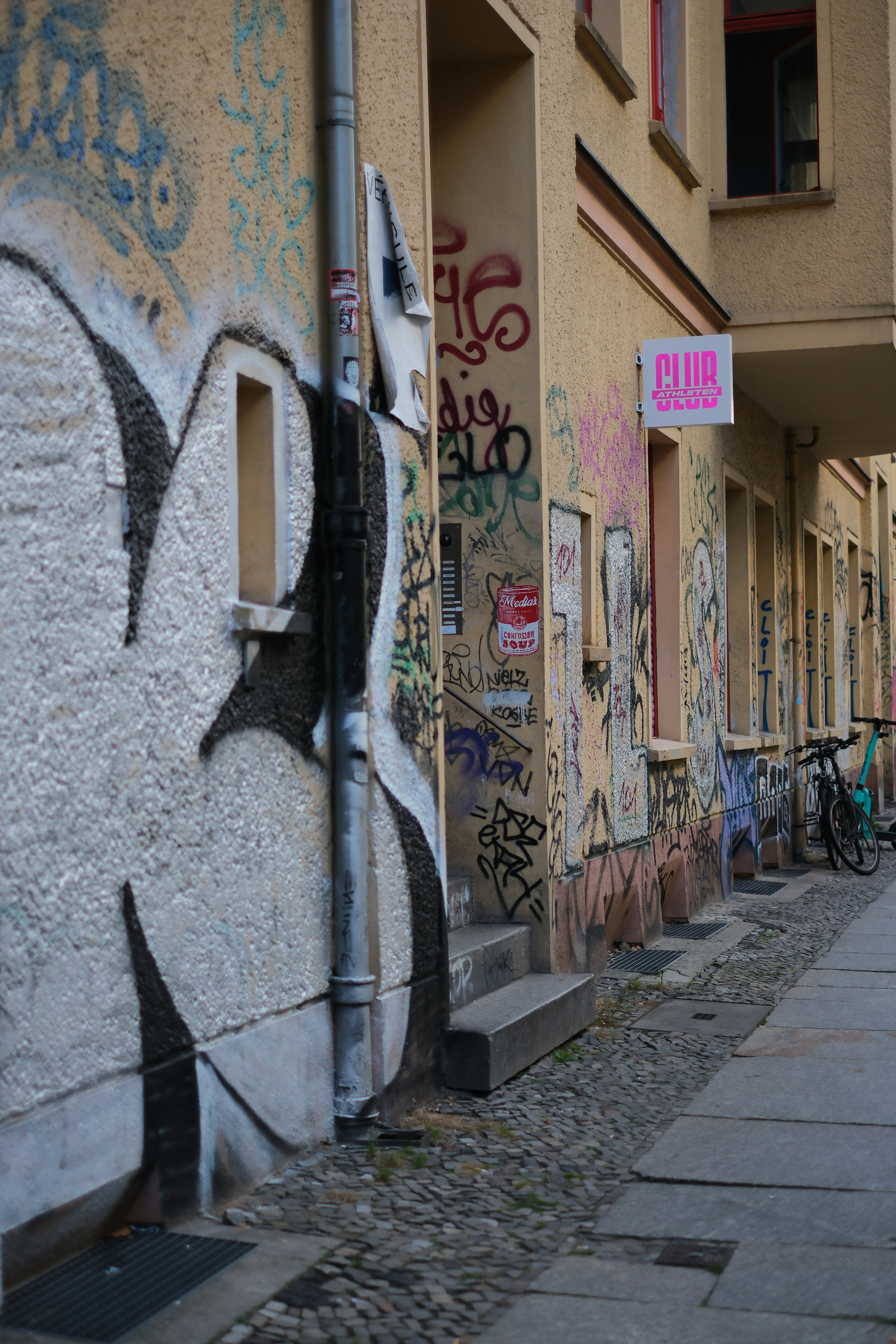 A narrow alley with graffiti on the walls - a-narrow-alley-with-graffiti-on-the-walls-FJEM-cVQnFc