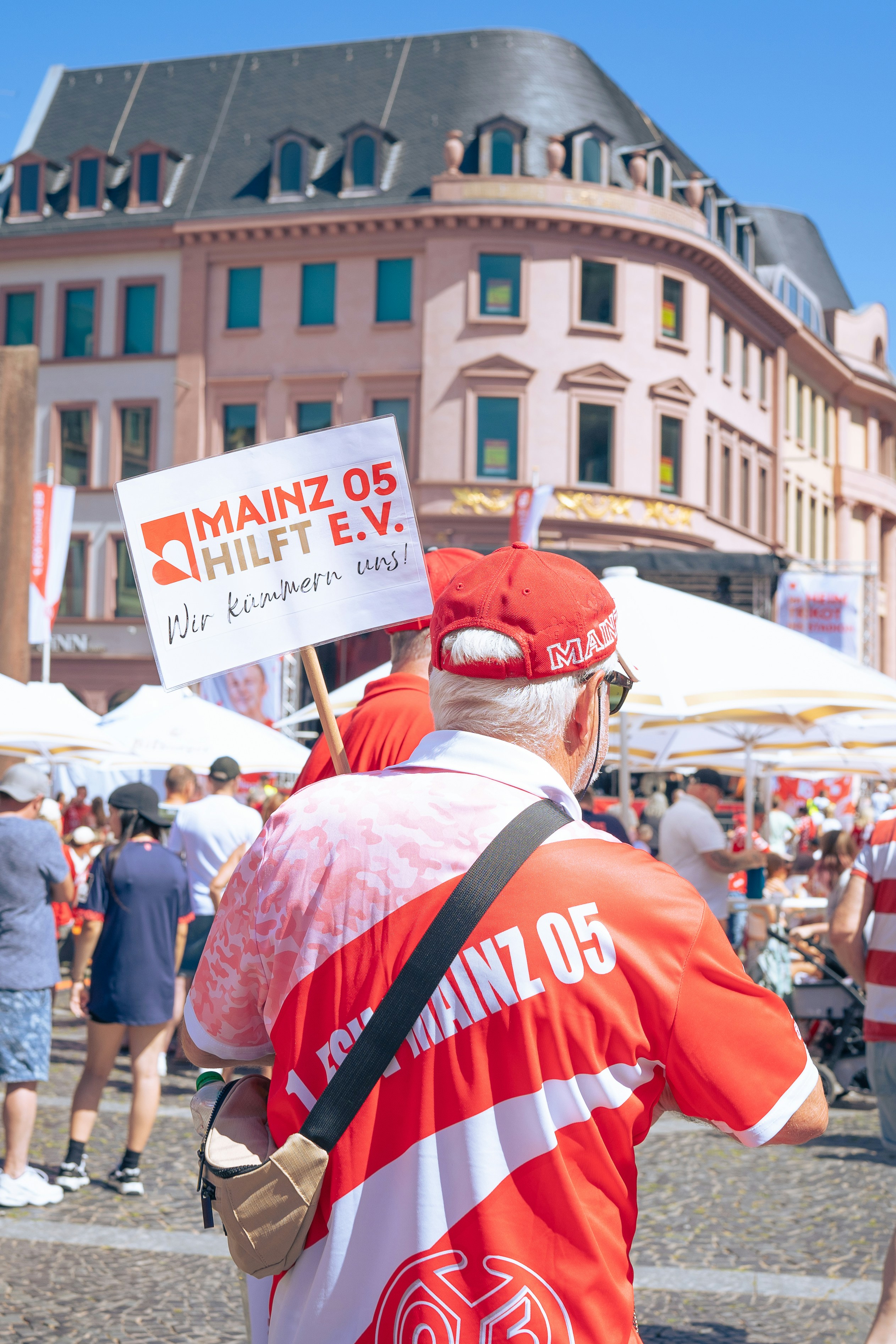 A man in a red and white shirt holding a sign