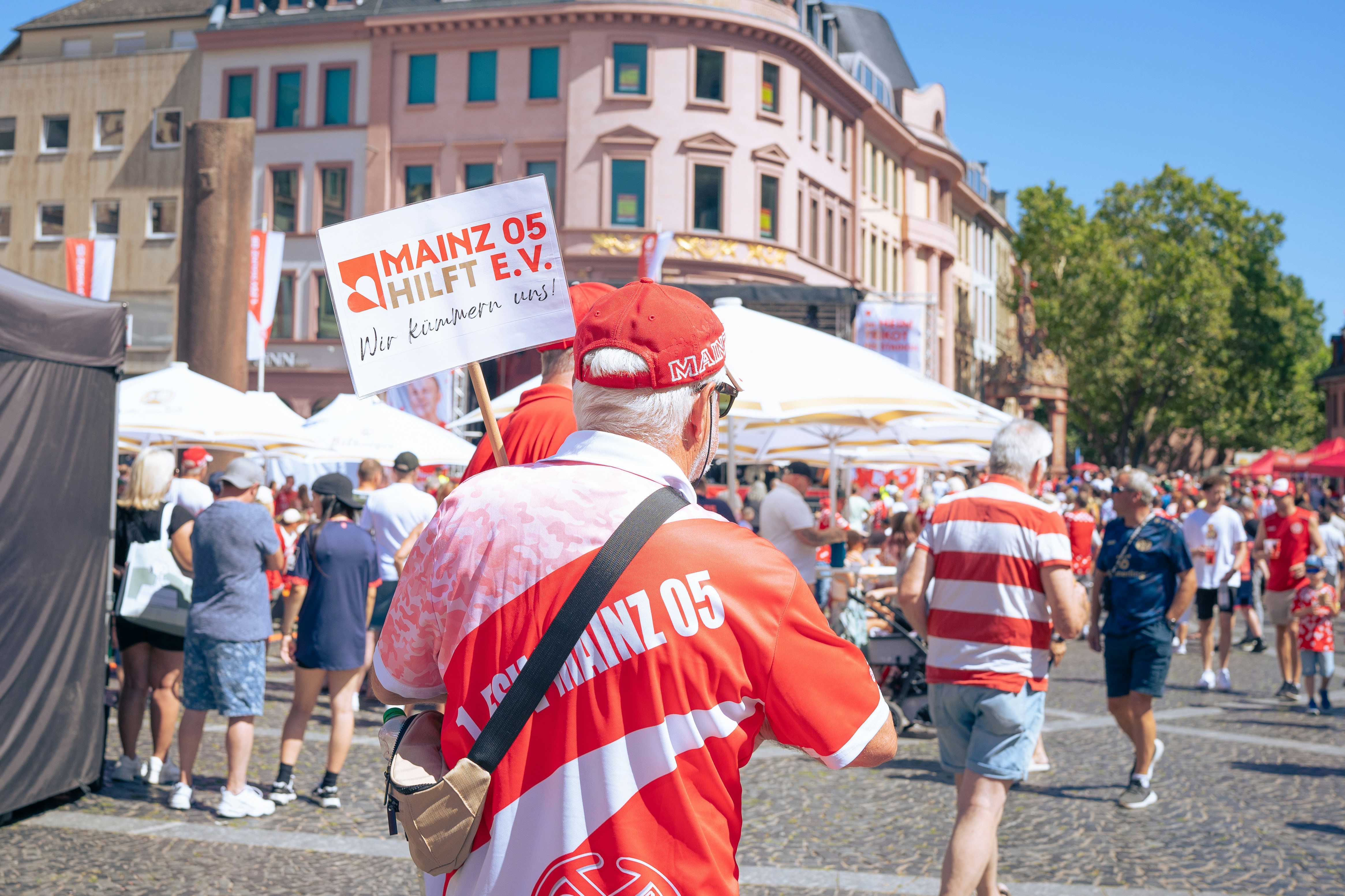 A man in a red and white shirt holding a sign