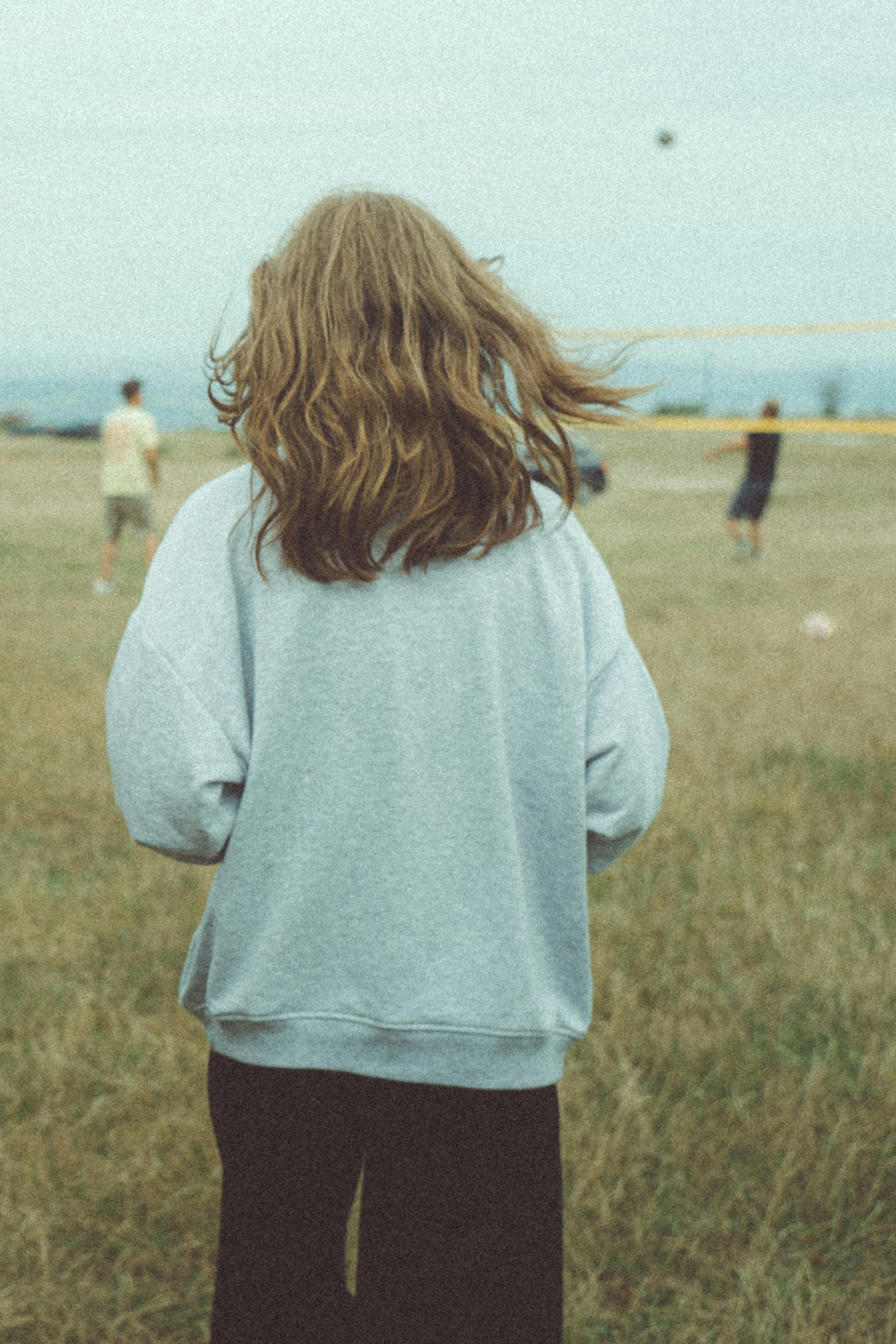 Eine Person, die auf einem Feld steht und einen Drachen steigen lässt