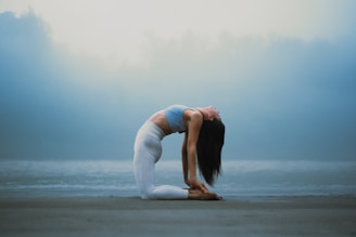 A woman doing a yoga pose on the beach