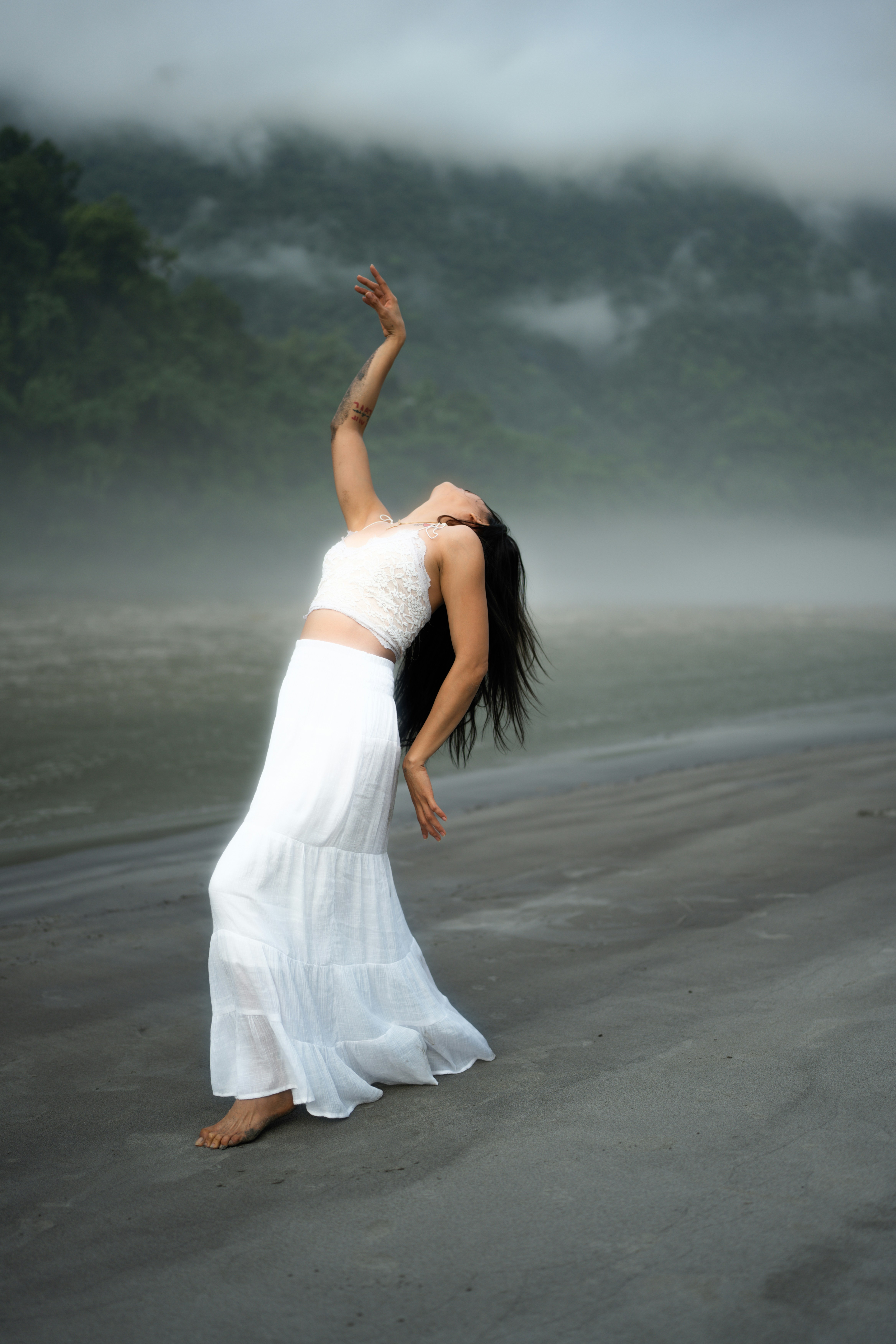 A woman in a white dress standing on a beach