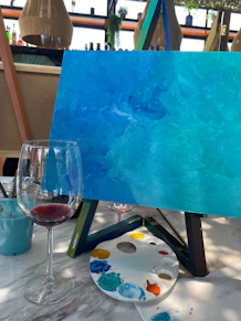 A painting and a glass of wine on a table