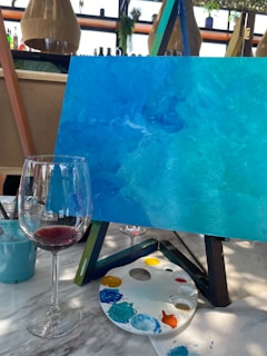 A painting and a glass of wine on a table