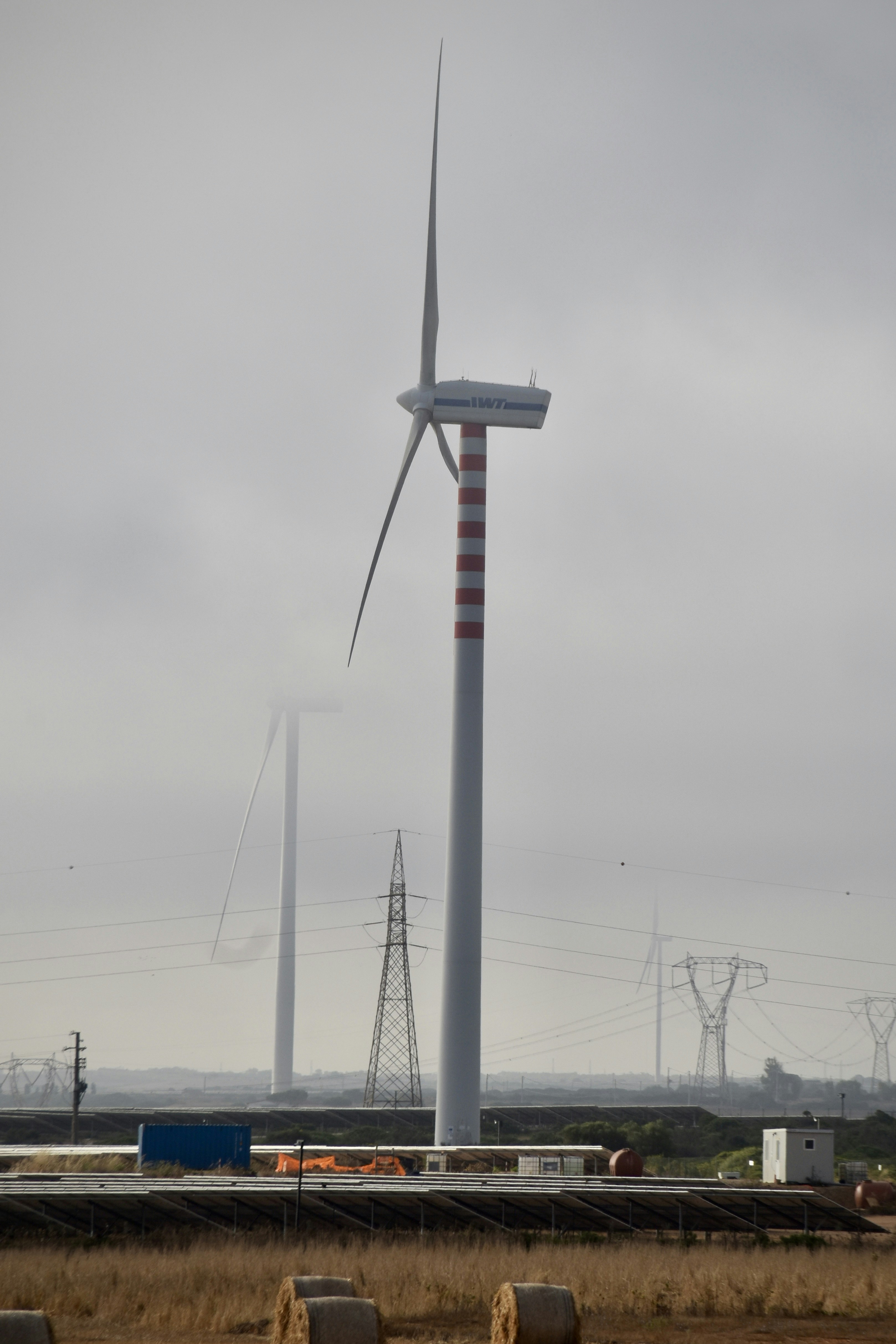 A wind farm with a wind turbine in the background