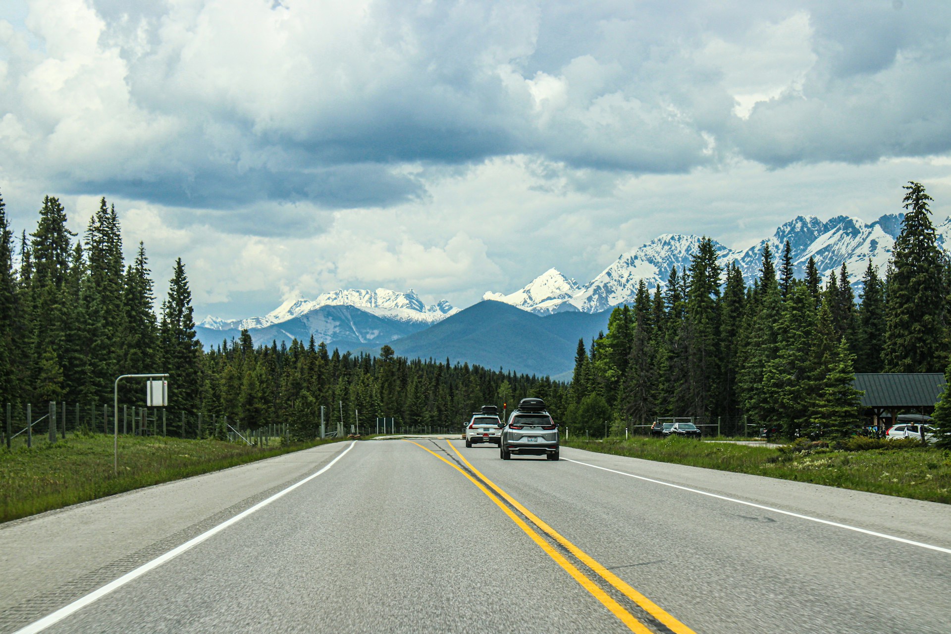 A car driving down a road with mountains in the background