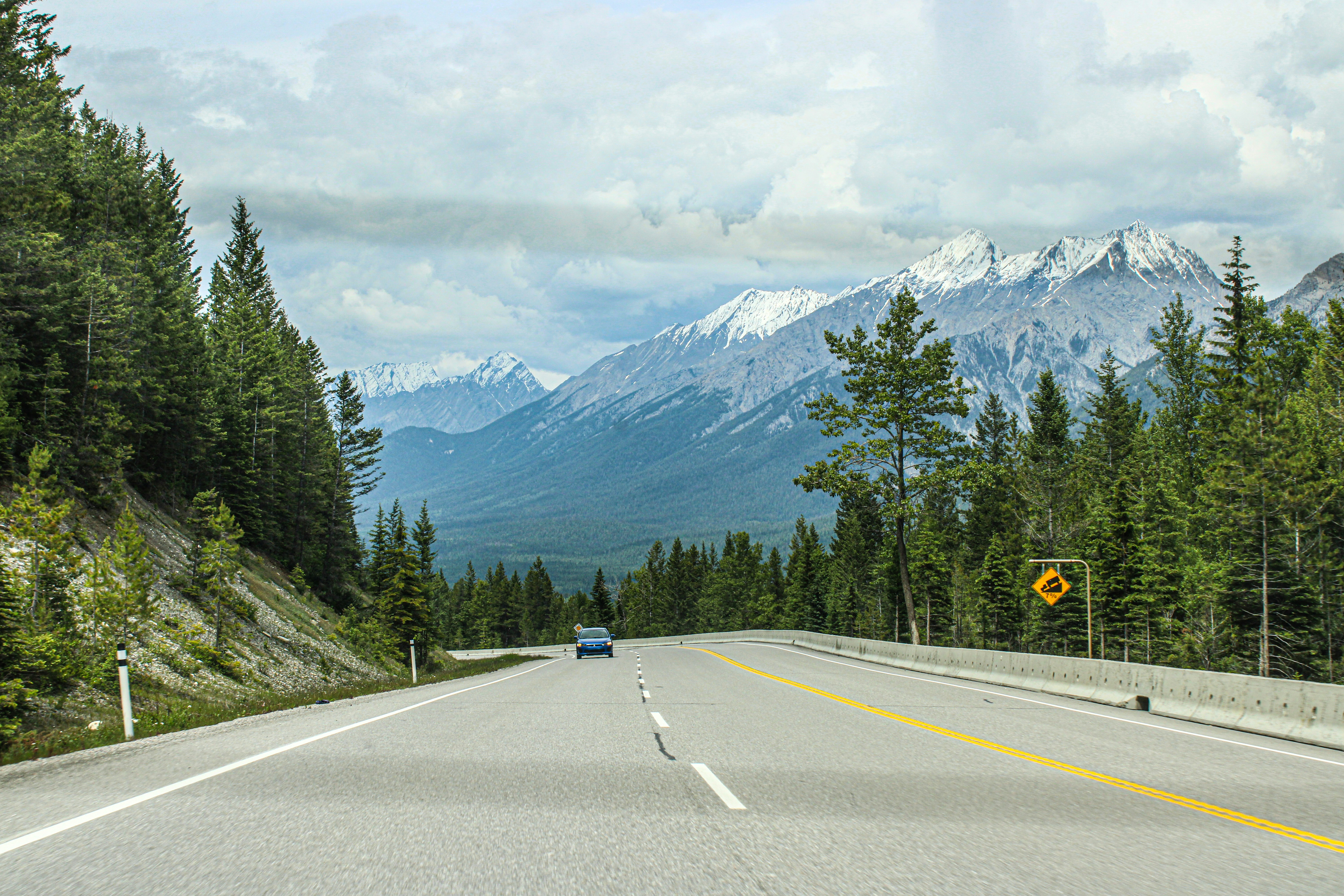 A car driving down a road with mountains in the background