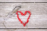 A heart made out of beads on a wooden surface