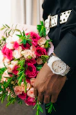 A man in a suit holding a bouquet of flowers