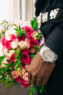 A man in a suit holding a bouquet of flowers