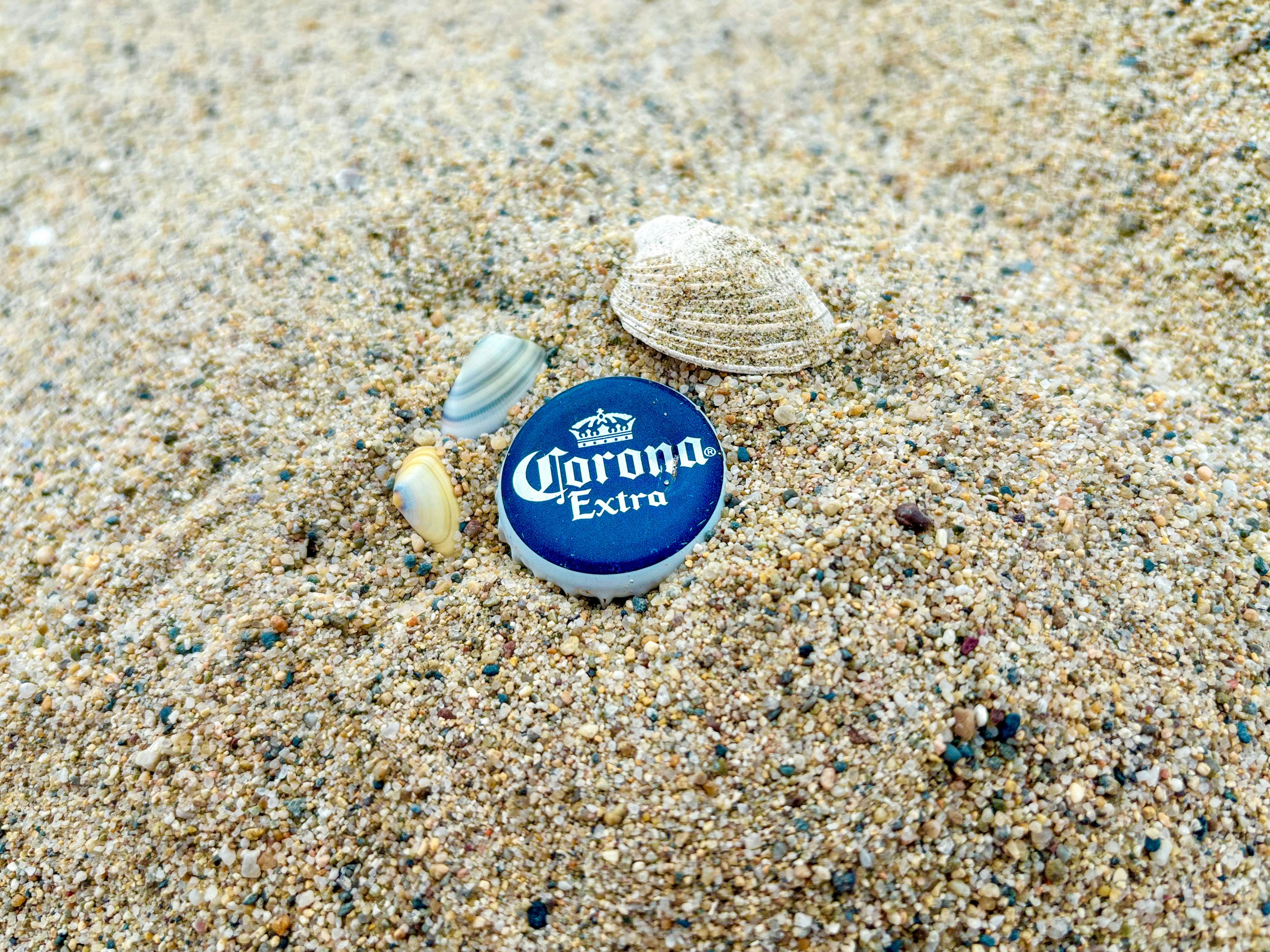 Ambiance estivale avec une bouteille de bière posée sur le sable de la plage