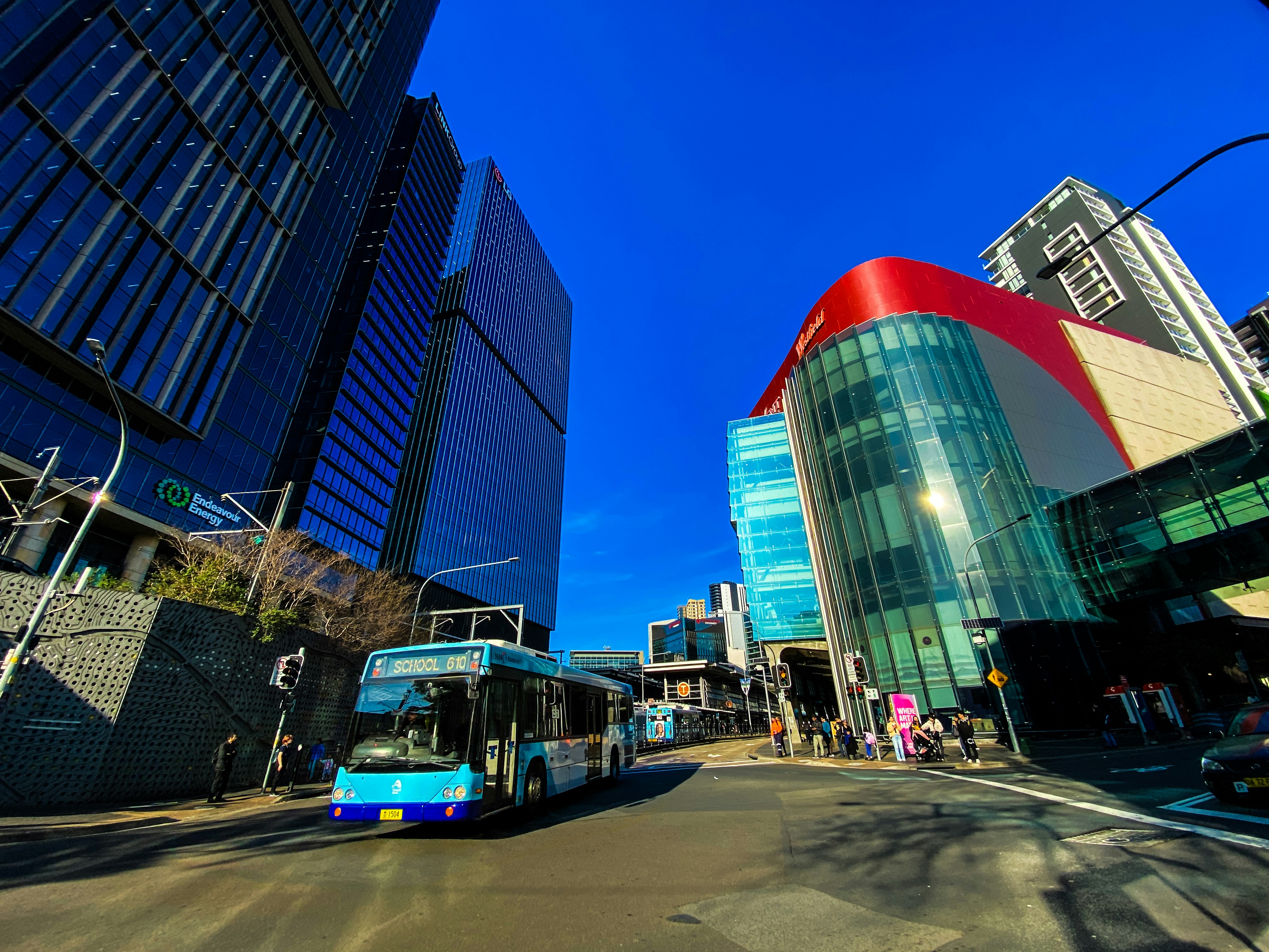 A bus driving down a street next to tall buildings, International Student Navigator Australia: Discover the vibrant city of Sydney through stunning visuals on Unsplash! 📸✨ From the iconic Sydney Opera House 🏛️ to the serene Bondi Beach 🏖️, explore breathtaking imagery capturing the essence of this multicultural metropolis 🌏. Perfect for international students seeking a glimpse into their future home, these photos offer a sneak peek into the diverse and dynamic lifestyle Sydney has to offer.