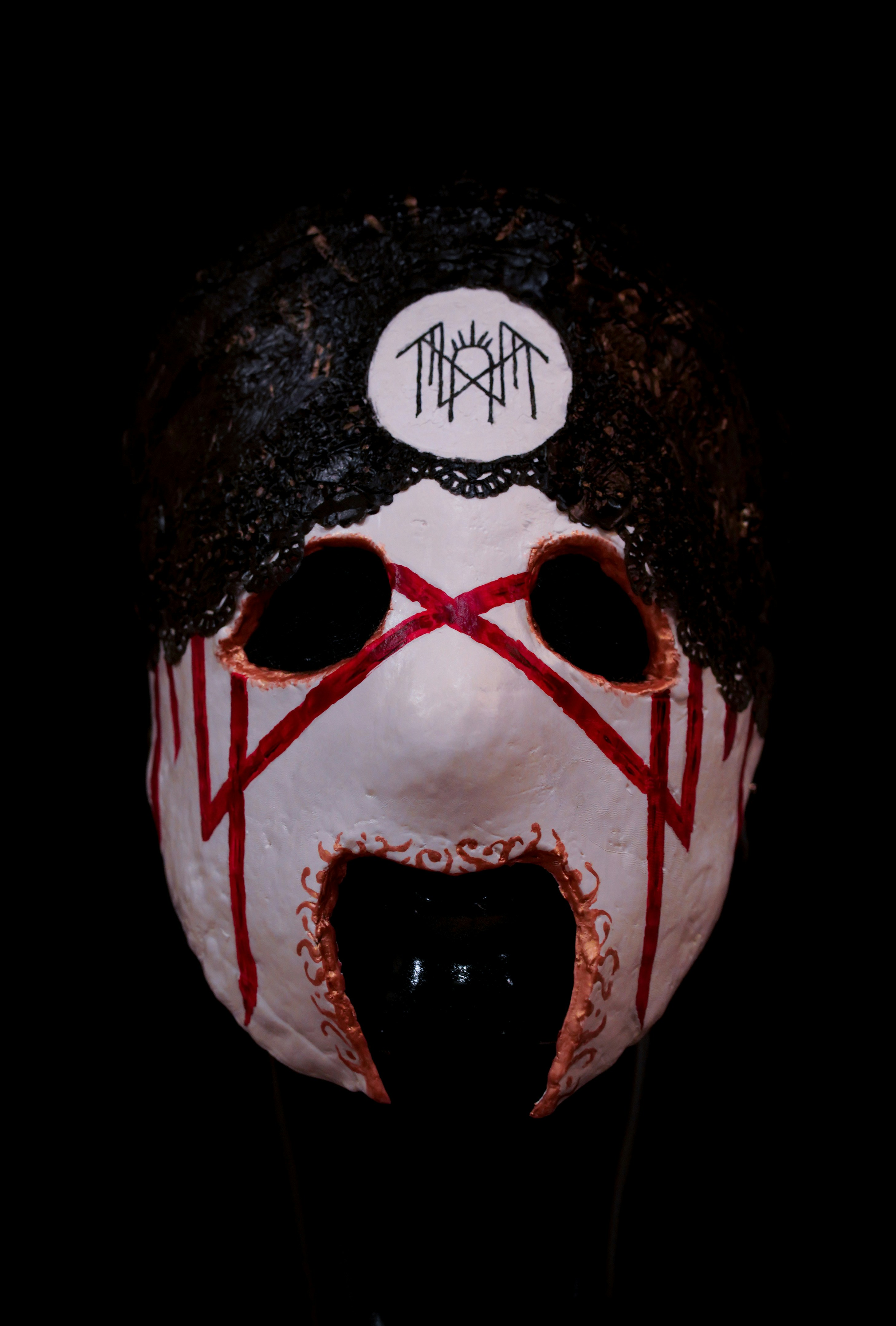 A person wearing a white mask with red lines on it