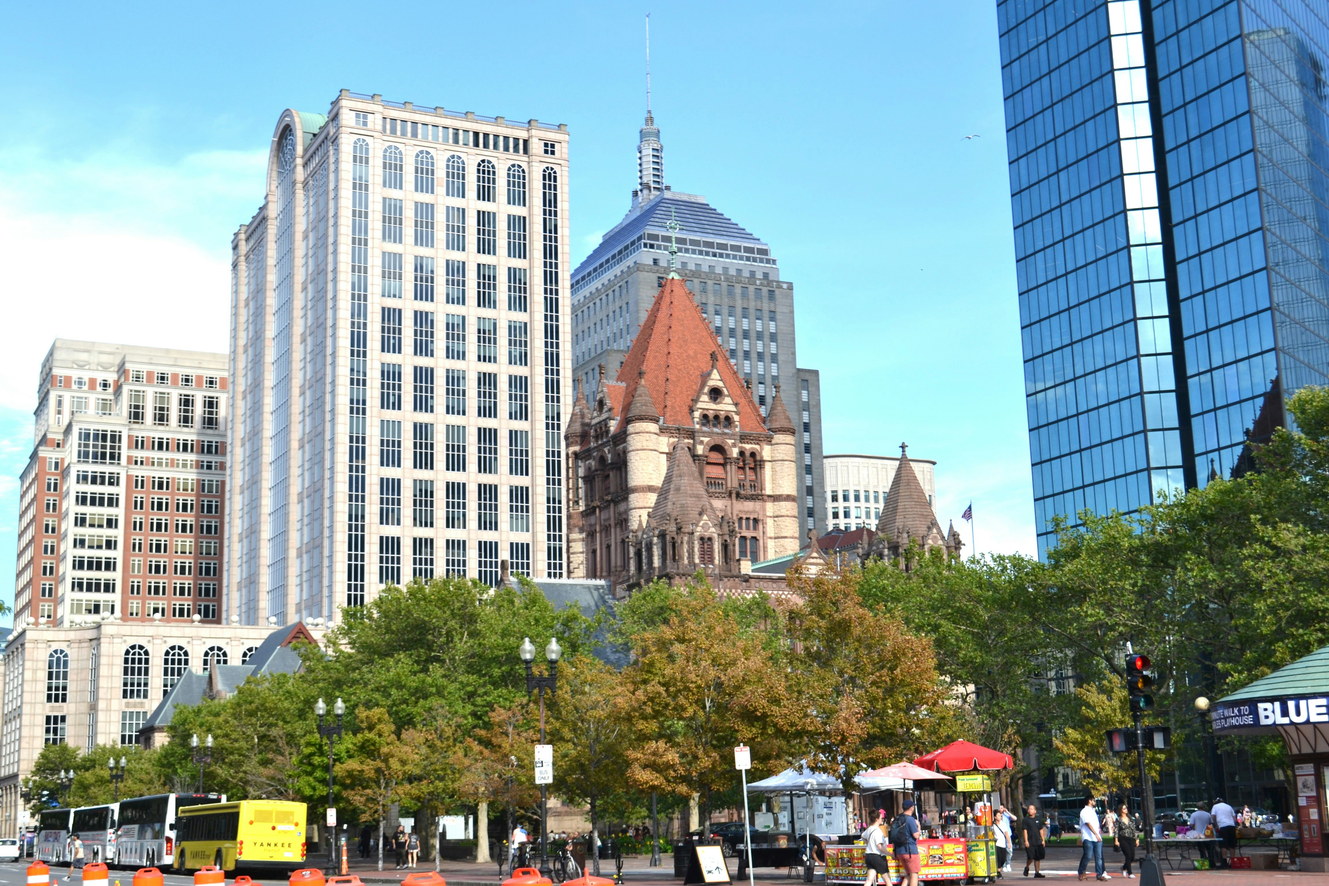A group of people walking down a street next to tall buildings