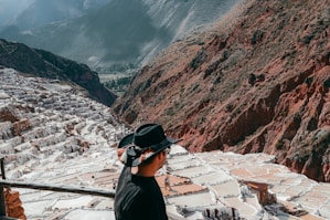 A man standing on top of a mountain next to a river