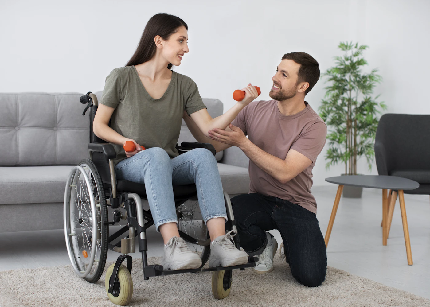 אשת צוות מלווה דייר מבוגר בכיסא גלגלים בבית אבות, בהמחשה של השגחה רפואית וזמינות צוות לאורך כל שעות היממה.