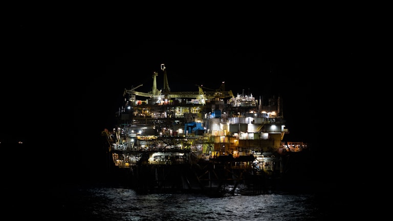 An oil rig in the middle of the ocean at night
