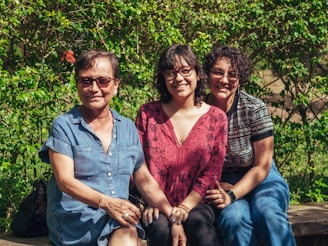 A group of three people sitting next to each other