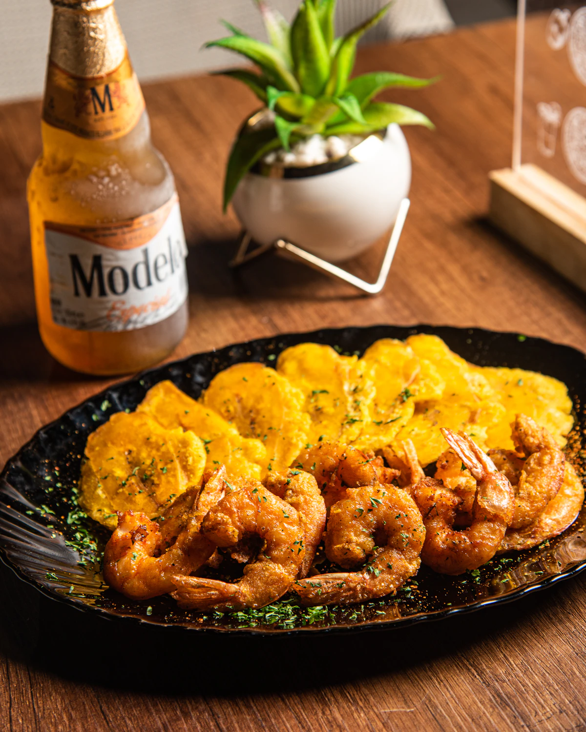 Plate of tostones and shrimp on a wooden table