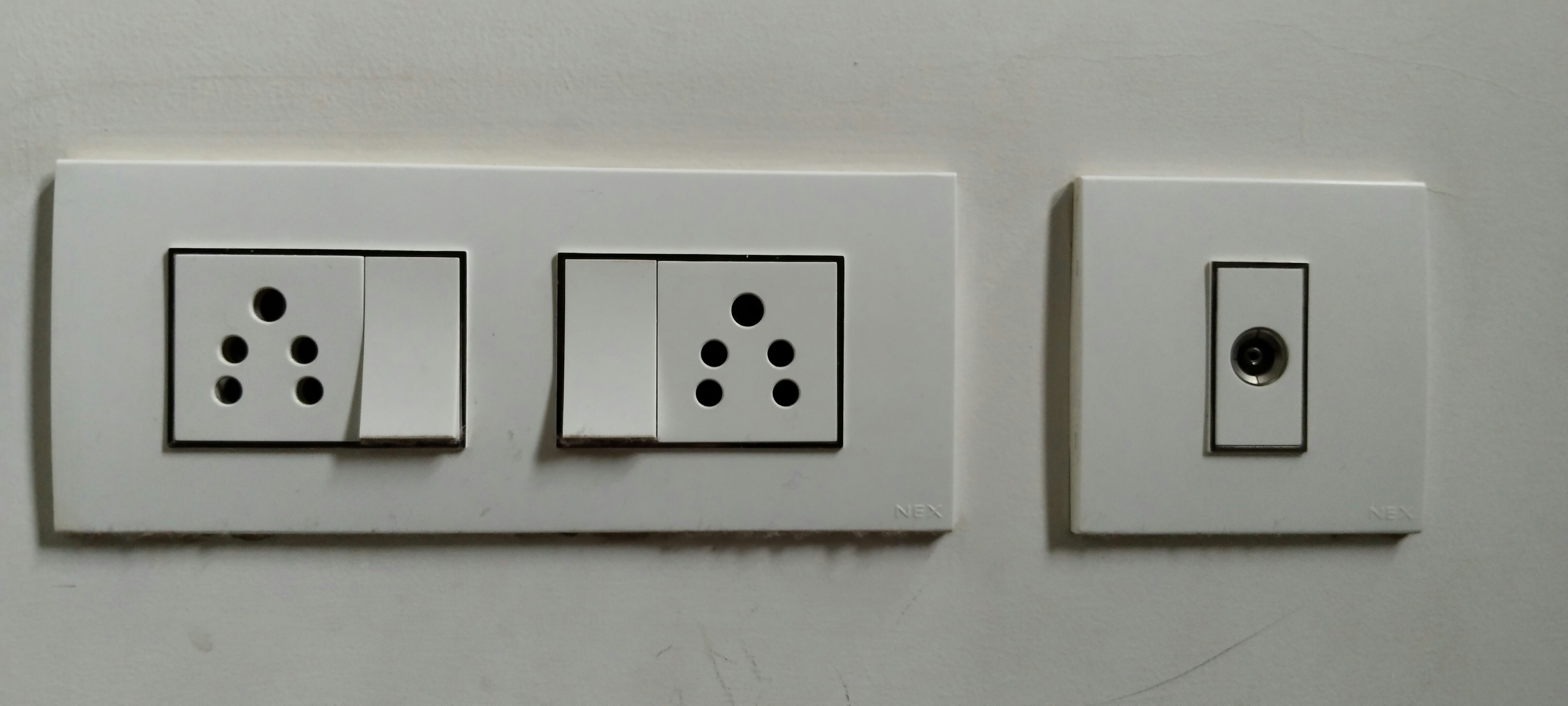 White modular electrical socket and switch plates on clean wall