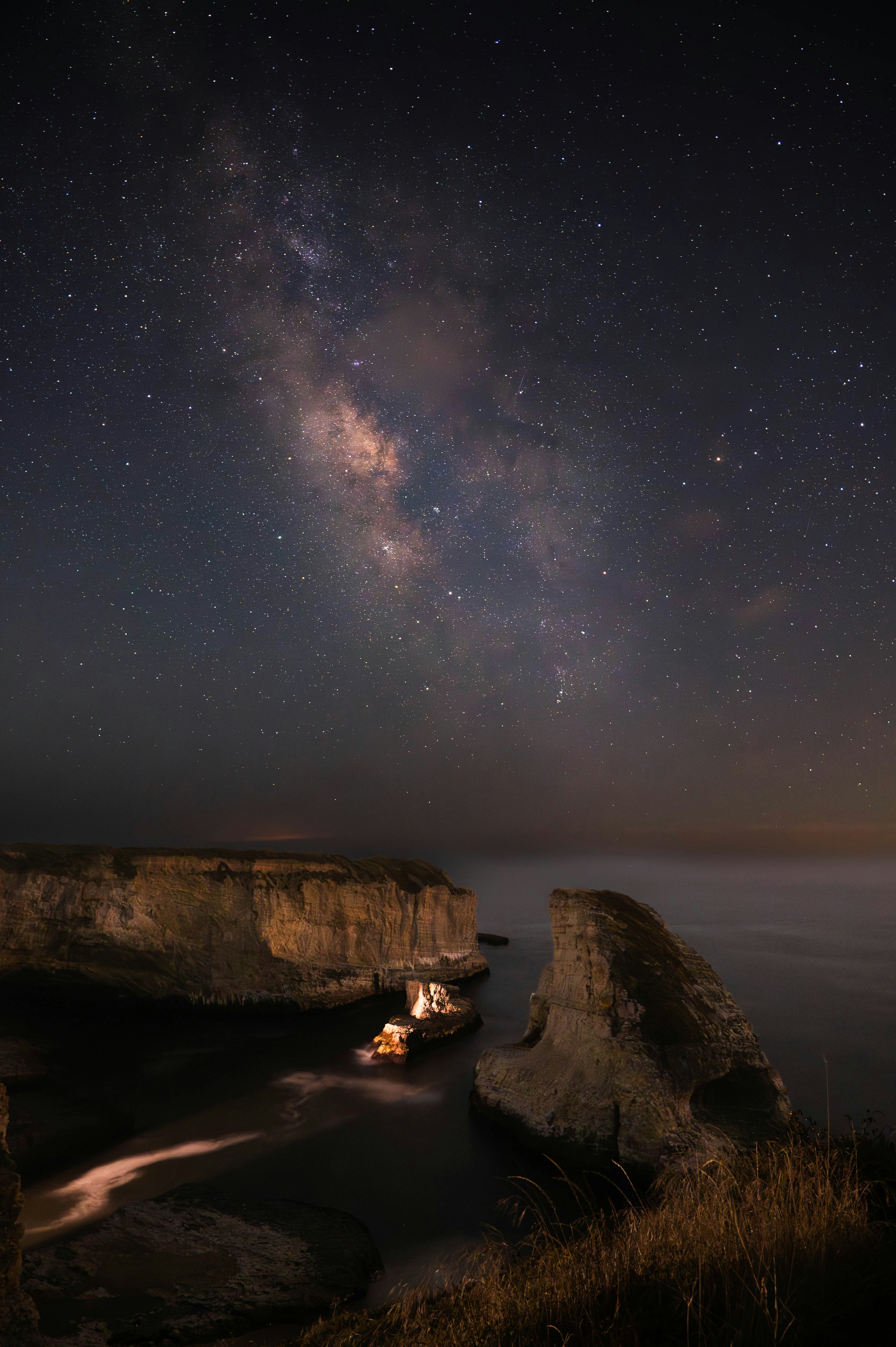A night sky filled with stars above a body of water