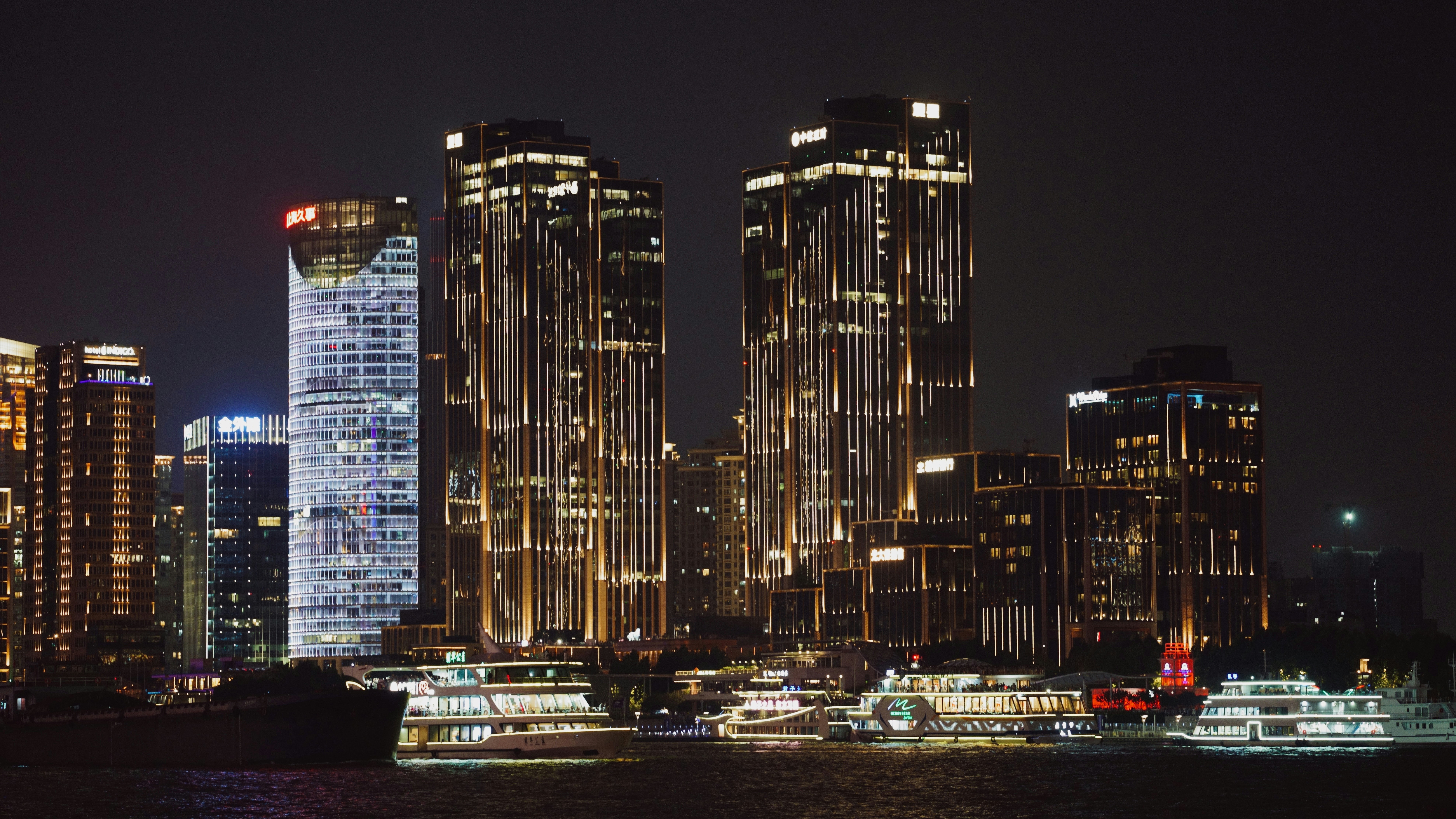 A city skyline at night with boats in the water photo – Free Night ...