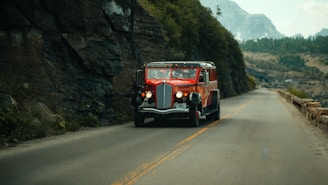A red and white bus driving down a mountain road