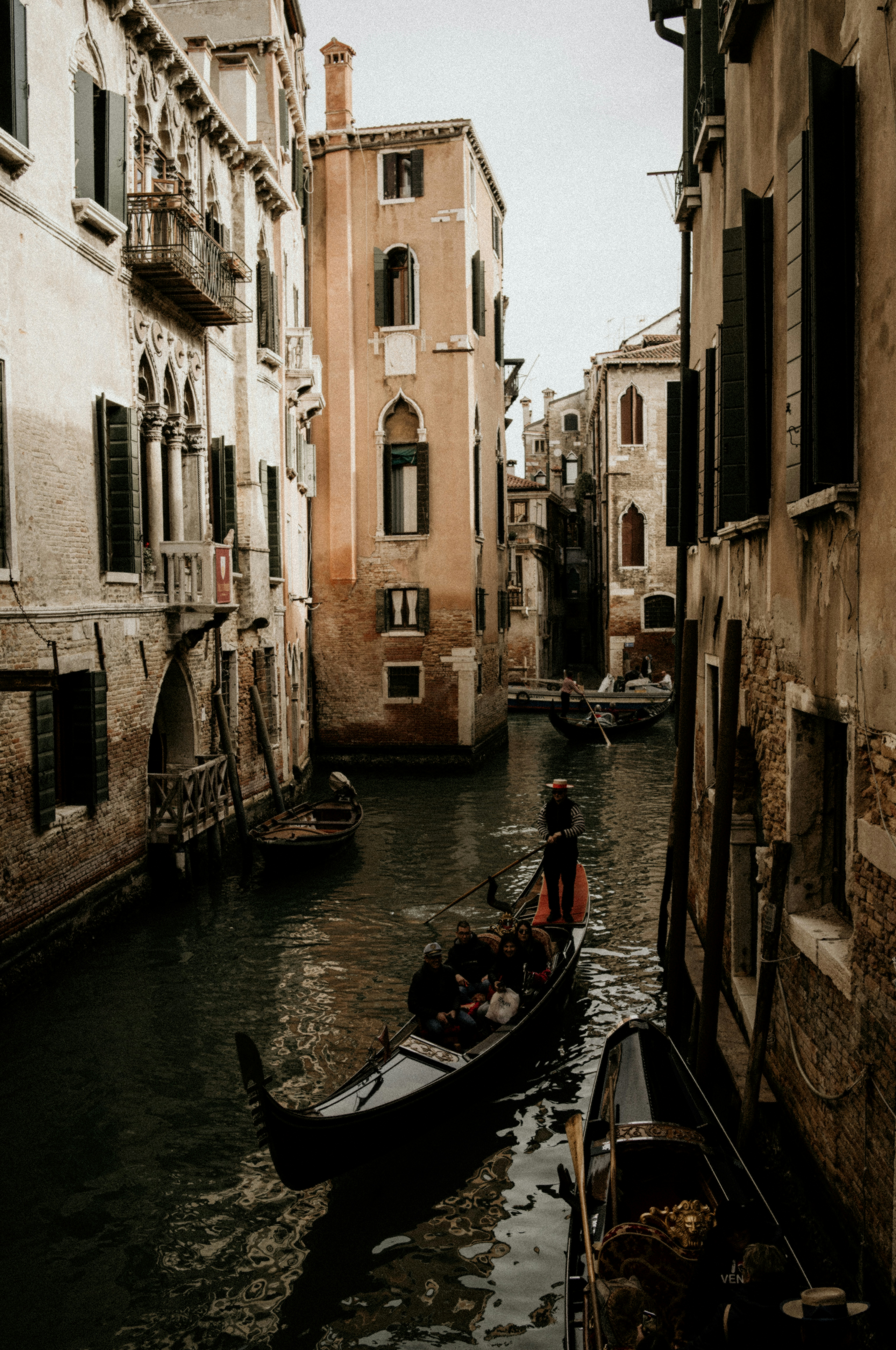 A small boat in a narrow canal between two buildings