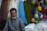 A man sitting in front of a display of yarn