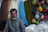 A man sitting in front of a display of yarn